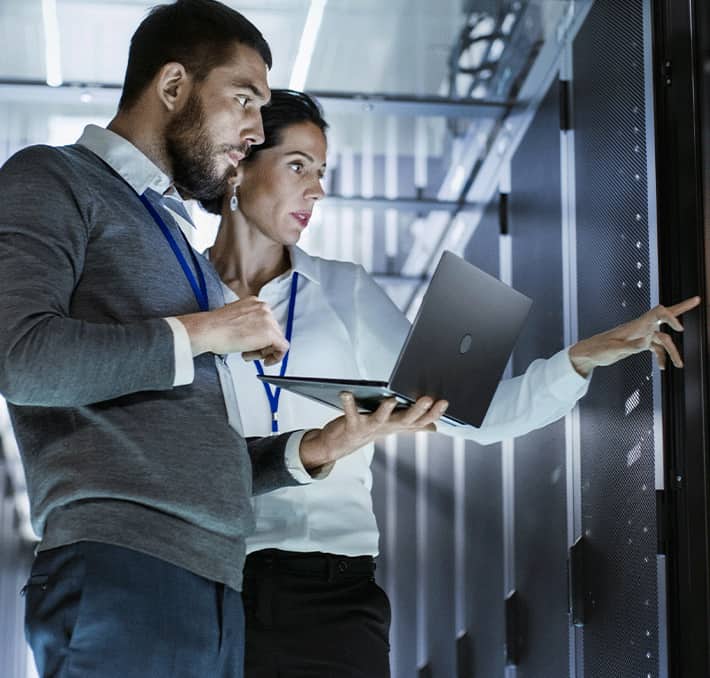 People looking at mainframe with laptop