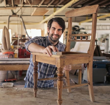 Man sanding a wooden chair
