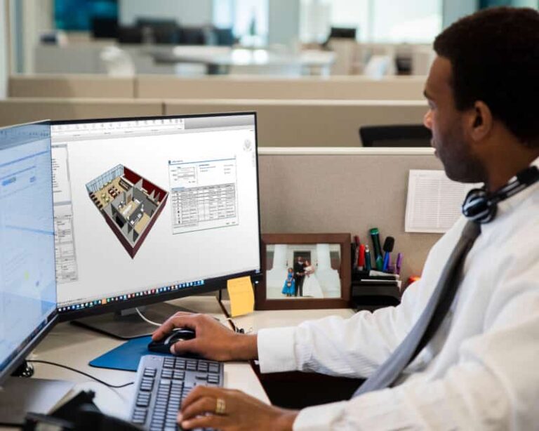 A man at a desk works on a computer displaying 3D architectural software, crafting innovative foodservice equipment design solutions.