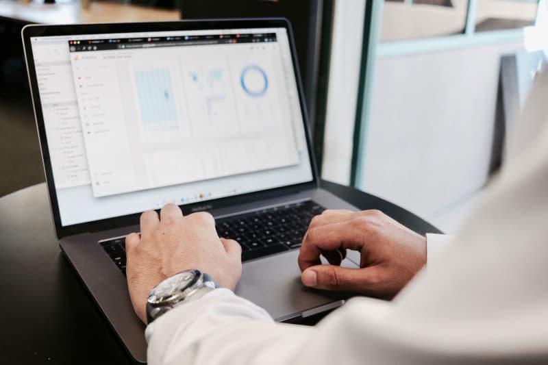 A focused individual is analyzing graphs and charts on their laptop, utilizing SpecQuote to enhance insights and drive strategic decisions.