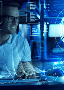 Person in glasses works on a computer with futuristic digital interfaces displaying data analysis and graphs.